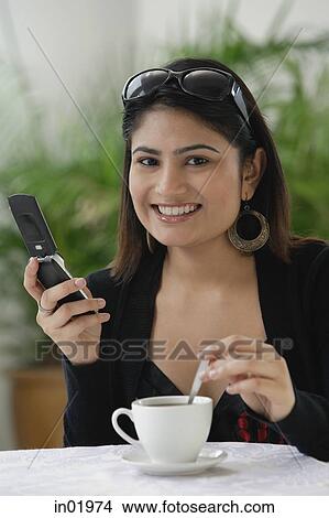 Woman in cafe, using mobile phone View Large Photo Image Picture - Woman in cafe, using mobile phone. Fotosearch