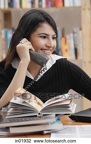 Woman in library, using telephone View Large Photo Image Stock Image - Woman in library, using telephone. Fotosearch