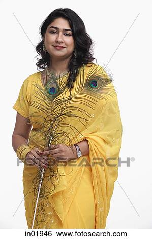 Woman in yellow sari holding peacock feather View Large Photo Image Stock Photograph - Woman in yellow sari holding peacock feather. Fotosearch