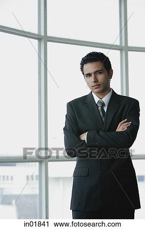 Young businessman arms crossed, looking at camera View Large Photo Image Stock Image - Young businessman arms crossed, looking at camera. Fotosearch