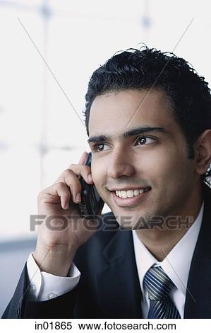 Young businessman on the phone, smiling, head shot View Large Photo Image Stock Photography - Young businessman on the phone, smiling, head shot. Fotosearch