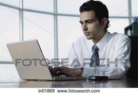 Young businessman using laptop View Large Photo Image Stock Photo - Young businessman using laptop. Fotosearch
