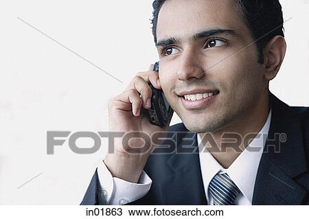 Young businessman using mobile phone, smiling View Large Photo Image Stock Image - Young businessman using mobile phone, smiling. Fotosearch
