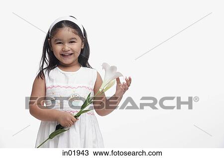 Young girl in white dress, holding a flower View Large Photo Image Stock Image - Young girl in white dress, holding a flower. Fotosearch