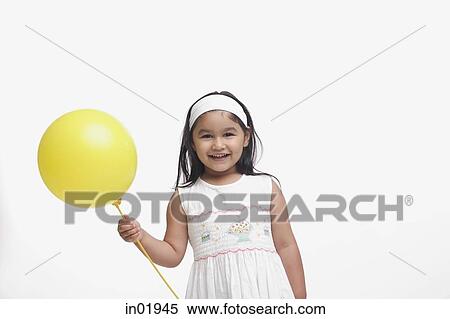 Young girl in white dress, holding a yellow balloon View Large Photo Image Stock Photography - Young girl in white dress, holding a yellow balloon. Fotosearch