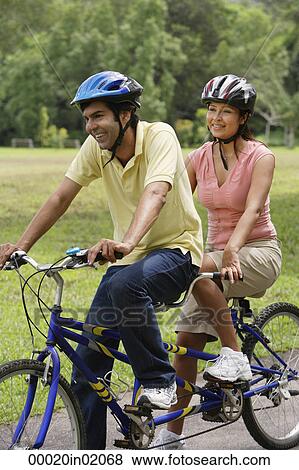 A couple ride a bike together View Large Photo Image Stock Photo - A couple ride a bike together. Fotosearch