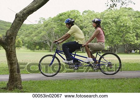 A couple ride a bike together View Large Photo Image Stock Photo - A couple ride a bike together. Fotosearch