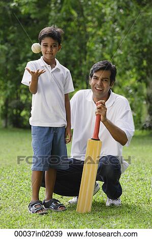 A father and son look at the camera as they play cricket together View Large Photo Image Stock Photo - A father and son look at the camera as they play cricket together. Fotosearch
