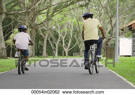 A father and son ride their bikes together View Large Photo Image Stock Image - A father and son ride their bikes together. Fotosearch