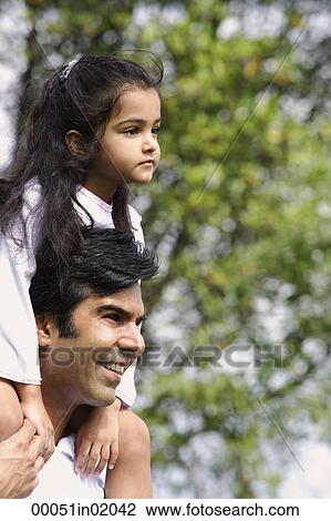 A father carries his daughter on his shoulders View Large Photo Image Stock Image - A father carries his daughter on his shoulders. Fotosearch