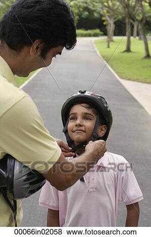 A father teaches his son to ride a bike View Large Photo Image Stock Photo - A father teaches his son to ride a bike. Fotosearch