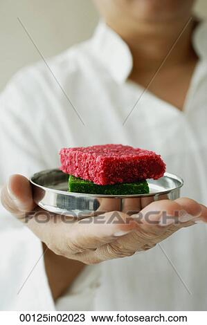 A man holds a dish of burfi View Large Photo Image Stock Image - A man holds a dish of burfi. Fotosearch