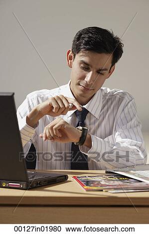A man looks at his watch to check the time View Large Photo Image Stock Image - A man looks at his watch to check the time. Fotosearch