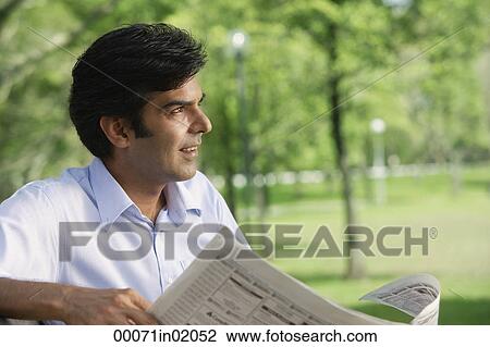 A man reads the newspaper in the park View Large Photo Image Stock Image - A man reads the newspaper in the park. Fotosearch
