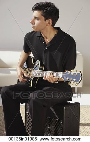 A man sits and plays the guitar View Large Photo Image Stock Photography - A man sits and plays the guitar. Fotosearch