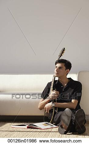 A man sits on the floor with his guitar View Large Photo Image Stock Photograph - A man sits on the floor with his guitar. Fotosearch
