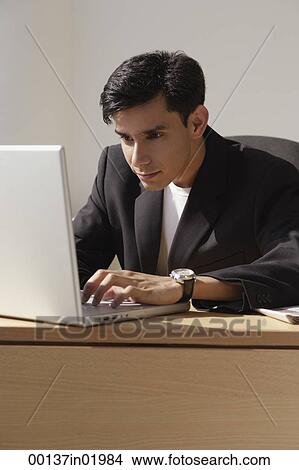 Picture - A man works on a laptop. Fotosearch