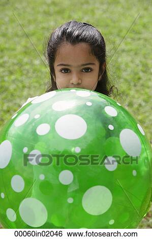 A small girl plays with a green ball View Large Photo Image Stock Photograph - A small girl plays with a green ball. Fotosearch