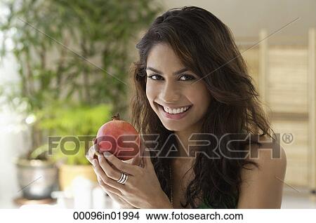 A woman eating fruit View Large Photo Image Picture - A woman eating fruit. Fotosearch