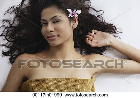 A woman lying down with flowers in her hair View Large Photo Image Stock Photo - A woman lying down with flowers in her hair. Fotosearch