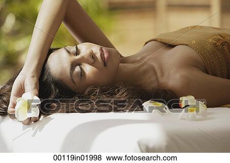 A woman lying down with frangipani flowers around her View Large Photo Image Stock Photo - A woman lying down with frangipani flowers around her. Fotosearch