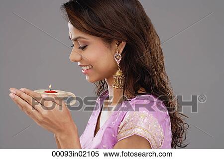 A young woman smiles as she holds a candle View Large Photo Image Stock Photography - A young woman smiles as she holds a candle. Fotosearch