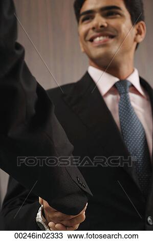Businessman smiling and shaking hands View Large Photo Image Stock Image - Businessman smiling and shaking hands. Fotosearch