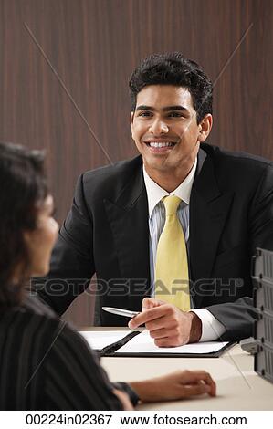 Businessman smiling at woman View Large Photo Image Stock Photo - Businessman smiling at woman. Fotosearch