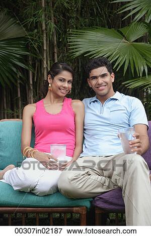 Couple on chairs outdoors, smiling at camera View Large Photo Image Stock Photo - Couple on chairs outdoors, smiling at camera. Fotosearch