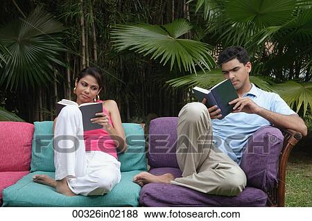 Couple reading on sofa outdoors View Large Photo Image Stock Photo - Couple reading on sofa outdoors. Fotosearch