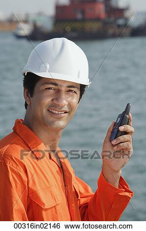 Man in work uniform smiling at camera View Large Photo Image Stock Photograph - Man in work uniform smiling at camera. Fotosearch