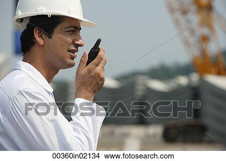 Man in work uniform, talking into walkie talkie View Large Photo Image Picture - Man in work uniform, talking into walkie talkie. Fotosearch