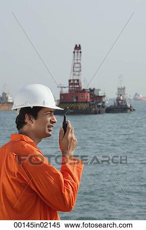 Man in work uniform talking into walkie talkie View Large Photo Image Stock Photography - Man in work uniform talking into walkie talkie. Fotosearch