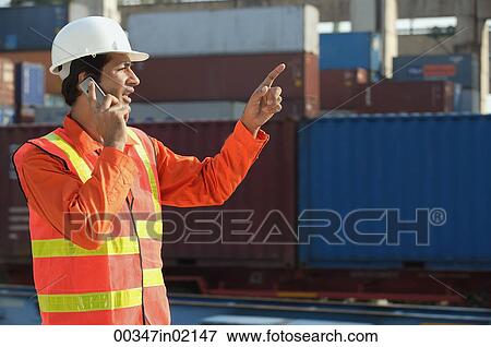 Stock Photo - Man in work uniform talking on mobile phone. Fotosearch