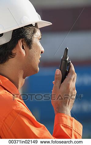 Man in work uniform using walkie talkie View Large Photo Image Stock Photo - Man in work uniform using walkie talkie. Fotosearch
