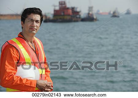 Stock Image - Man in work uniform working at port. Fotosearch