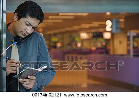 Man making notes while on the phone View Large Photo Image Stock Image - Man making notes while on the phone. Fotosearch