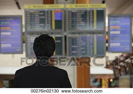 Man reading departure table at airport View Large Photo Image Stock Image - Man reading departure table at airport. Fotosearch