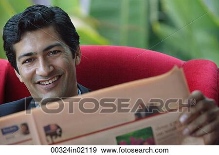 Man reading financial newspaper, smiling at camera View Large Photo Image Stock Photo - Man reading financial newspaper, smiling at camera. Fotosearch