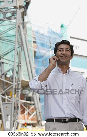 Man smiling while on mobile phone View Large Photo Image Stock Photography - Man smiling while on mobile phone. Fotosearch