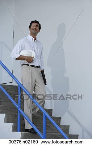 Man smiling while walking down stairs View Large Photo Image Stock Image - Man smiling while walking down stairs. Fotosearch