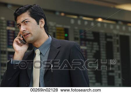 Man talking on phone at airport View Large Photo Image Stock Photo - Man talking on phone at airport. Fotosearch