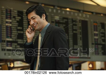 Man talking on the phone at airport View Large Photo Image Stock Photograph - Man talking on the phone at airport. Fotosearch
