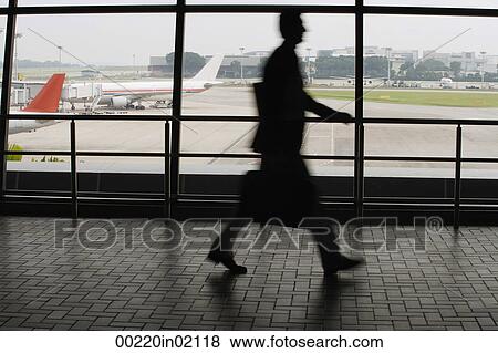 Man walking in airport View Large Photo Image Stock Photo - Man walking in airport. Fotosearch