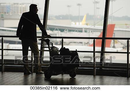 Man watching planes at airport View Large Photo Image Stock Photograph - Man watching planes at airport. Fotosearch