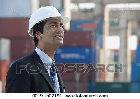 Stock Image - Man with helmet looking up. Fotosearch