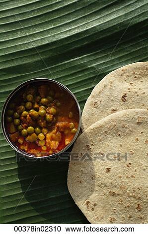 Stock Image - Still life of chapati and mixed vegetable curry on a banana leaf. Fotosearch