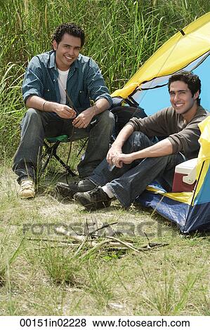 Stock Photo - Two friends camping smiling at camera. Fotosearch