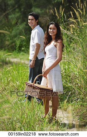 Stock Photo - Young couple going for a picnic. Fotosearch