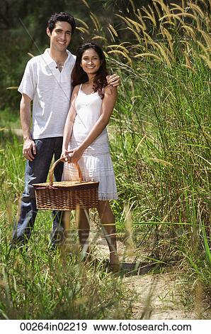 Stock Photo - Young couple going for a picnic. Fotosearch